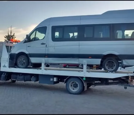 Lausof flatbed tow truck carrying a Sprinter minibus